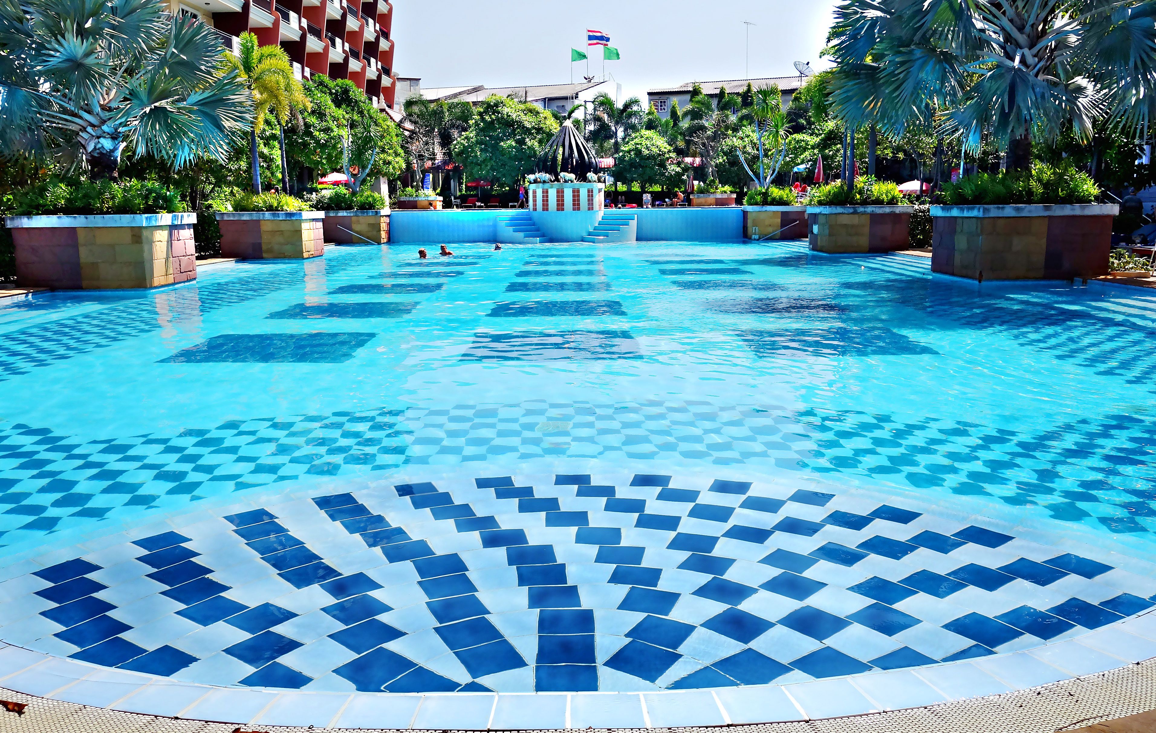 Alberca al aire libre, sombrillas en la alberca y camastros 