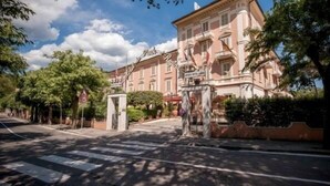 A historic building with a classic architectural style, a pedestrian crossing, and a clear sky. - Grand Hotel du Park et Regina (Montecatini Terme)