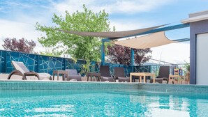 A swimming pool with lounge chairs and a shaded area. - Sure Hotel by Best Western Beziers Le Monestie (Boujan-sur-Libron)