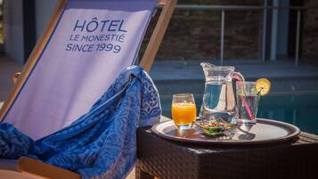 Ein Hotelschild, ein Tisch mit Tablett, ein Glas Orangensaft, eine Kanne und ein Glas mit Strohhalm.