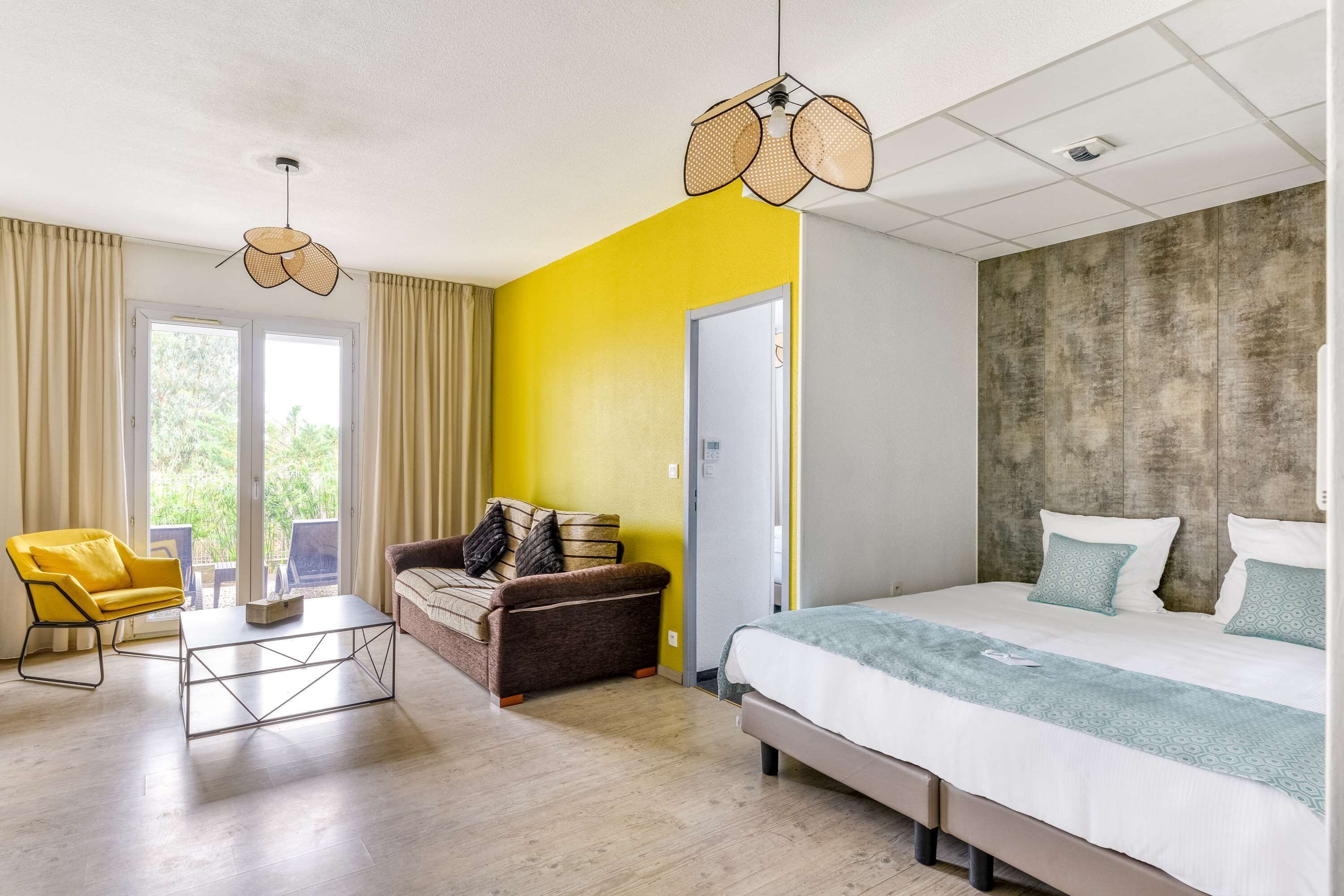 Un dormitorio moderno con una cama, un sofá, una mesa de centro y una silla.