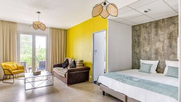 Un dormitorio moderno con una cama, un sofá, una mesa de centro y una silla.