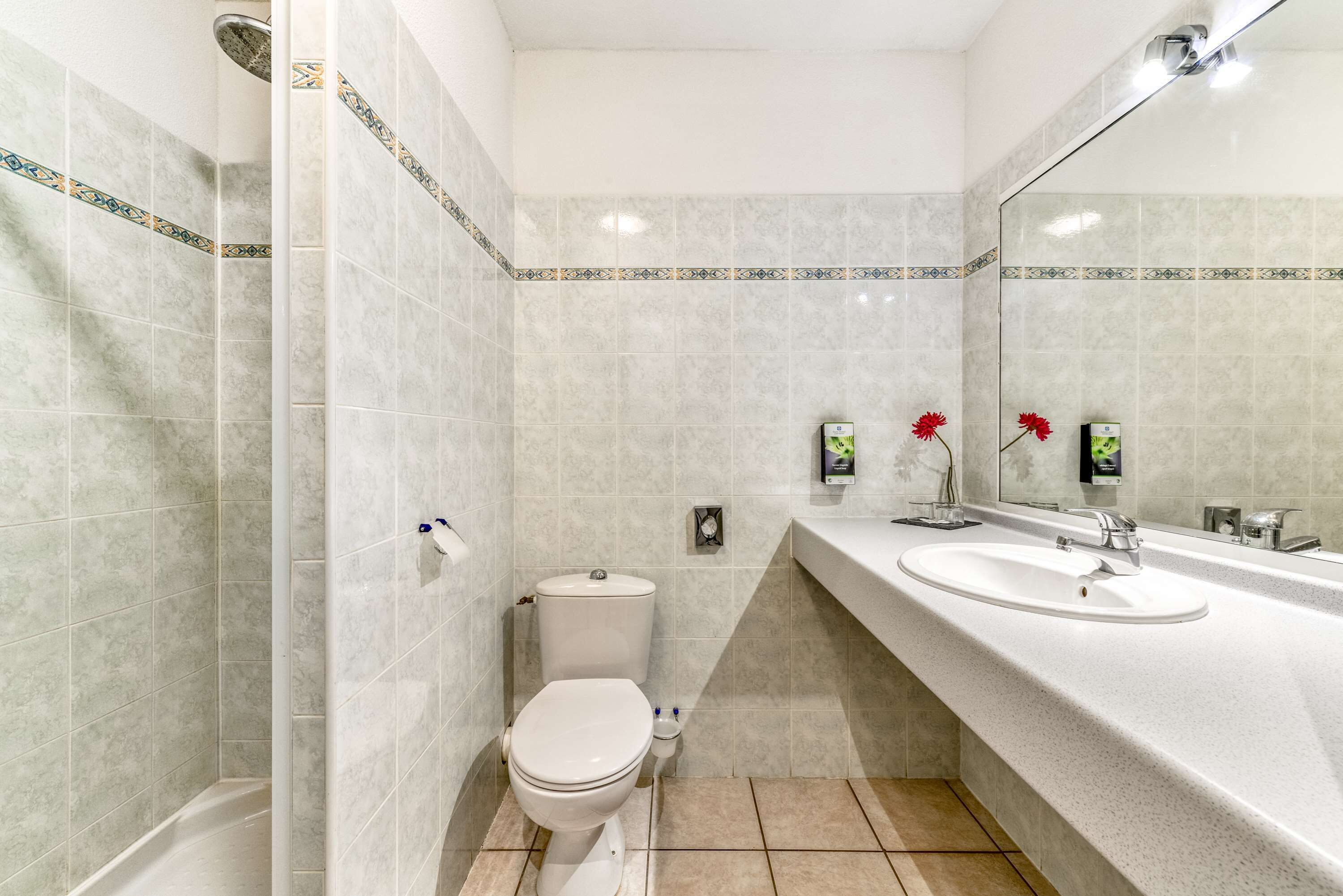 A bathroom with a toilet, sink, and shower.