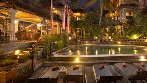 A pool area with lounge chairs and a stone fountain. - Ketut's Place Bed & Breakfast Ubud (Ubud)