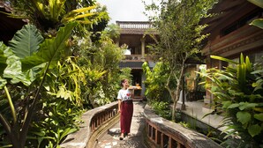 A pathway leading to a traditional building with a balcony, surrounded by lush greenery. - Ketut's Place Bed & Breakfast Ubud (Ubud)