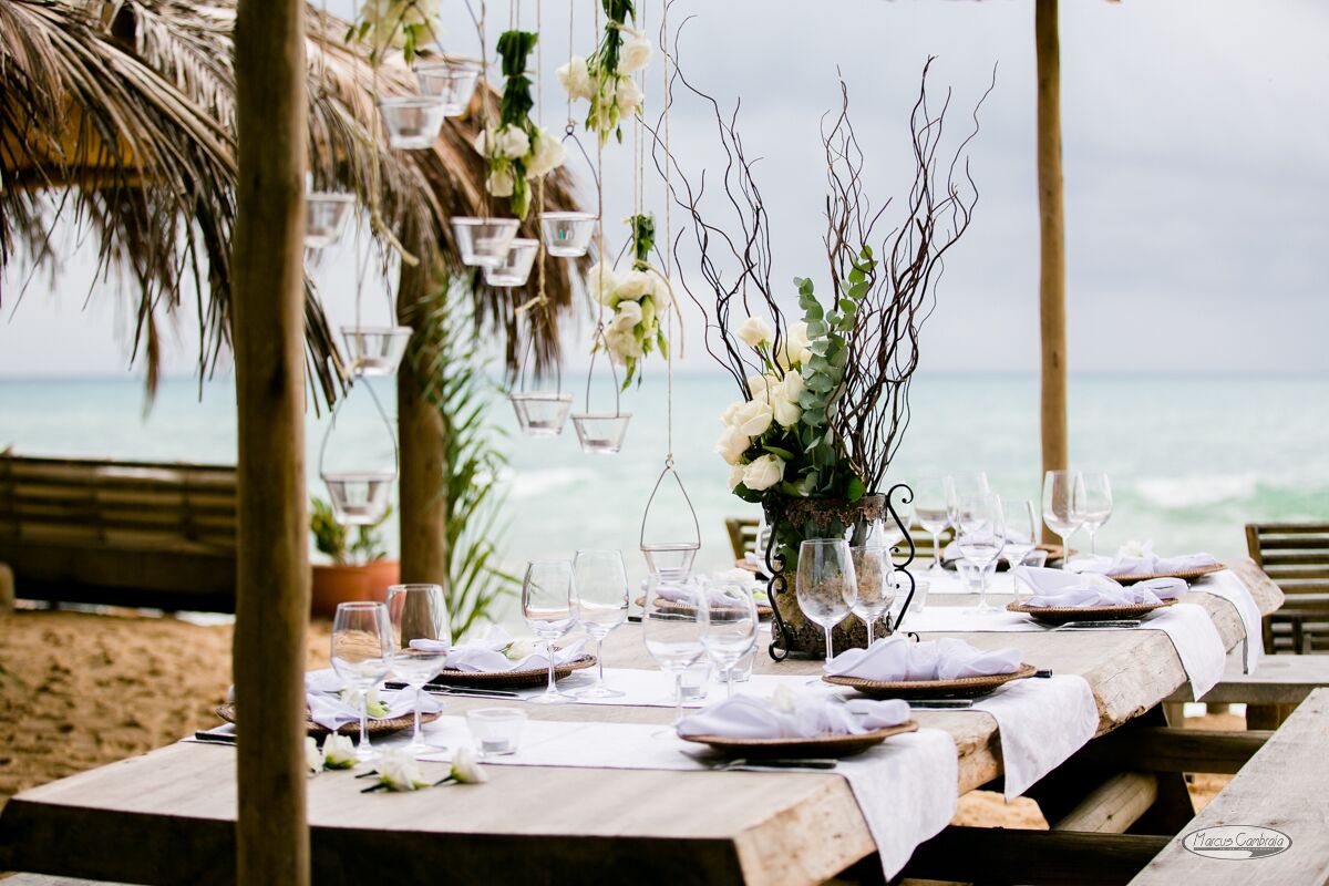 An outdoor dining setup with tables set for a meal, overlooking the ocean.