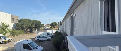 A parking area with several vehicles, including a white van and a black car.