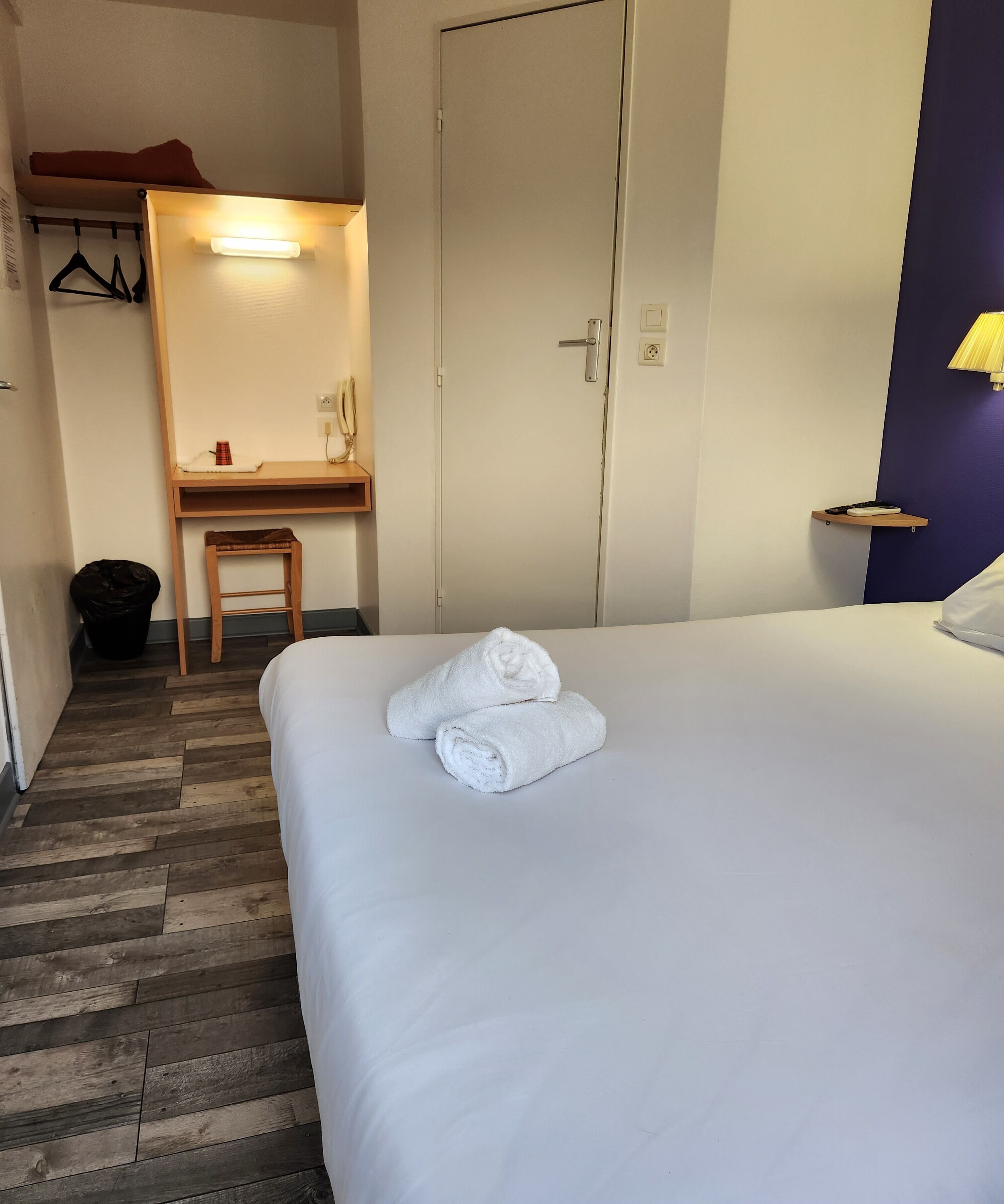 Une chambre d’hôtel avec un lit, un bureau et une chaise.