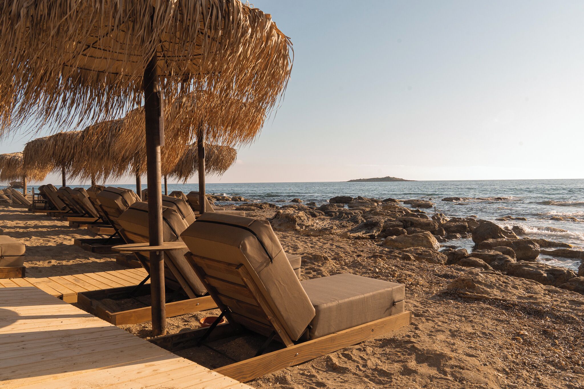 On the beach, black sand, sun loungers, beach umbrellas