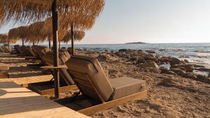 Sur la plage, sable noir, chaise longue, parasol
