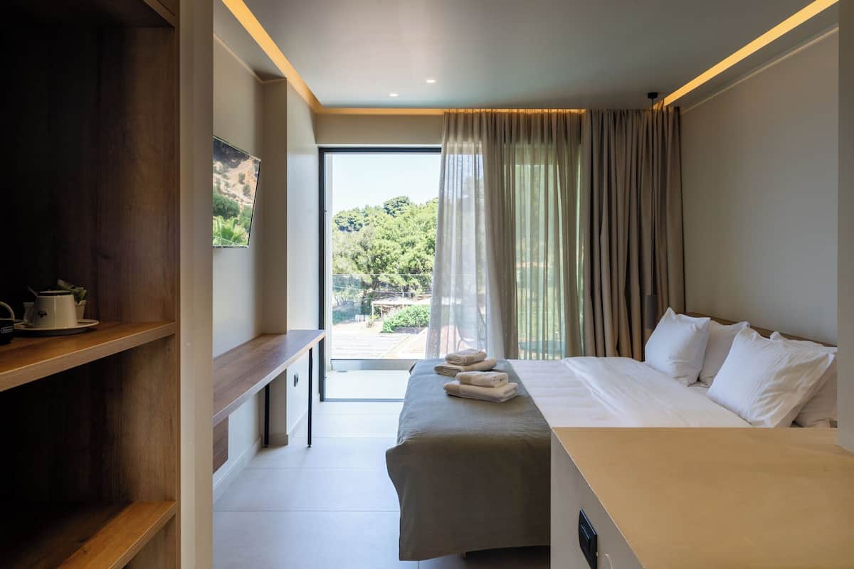 Deluxe tweepersoonskamer, 1 kingsize bed, gedeeltelijk uitzicht op zee, aan het strand | 1 slaapkamer, een minibar, een kluis op de kamer, een bureau