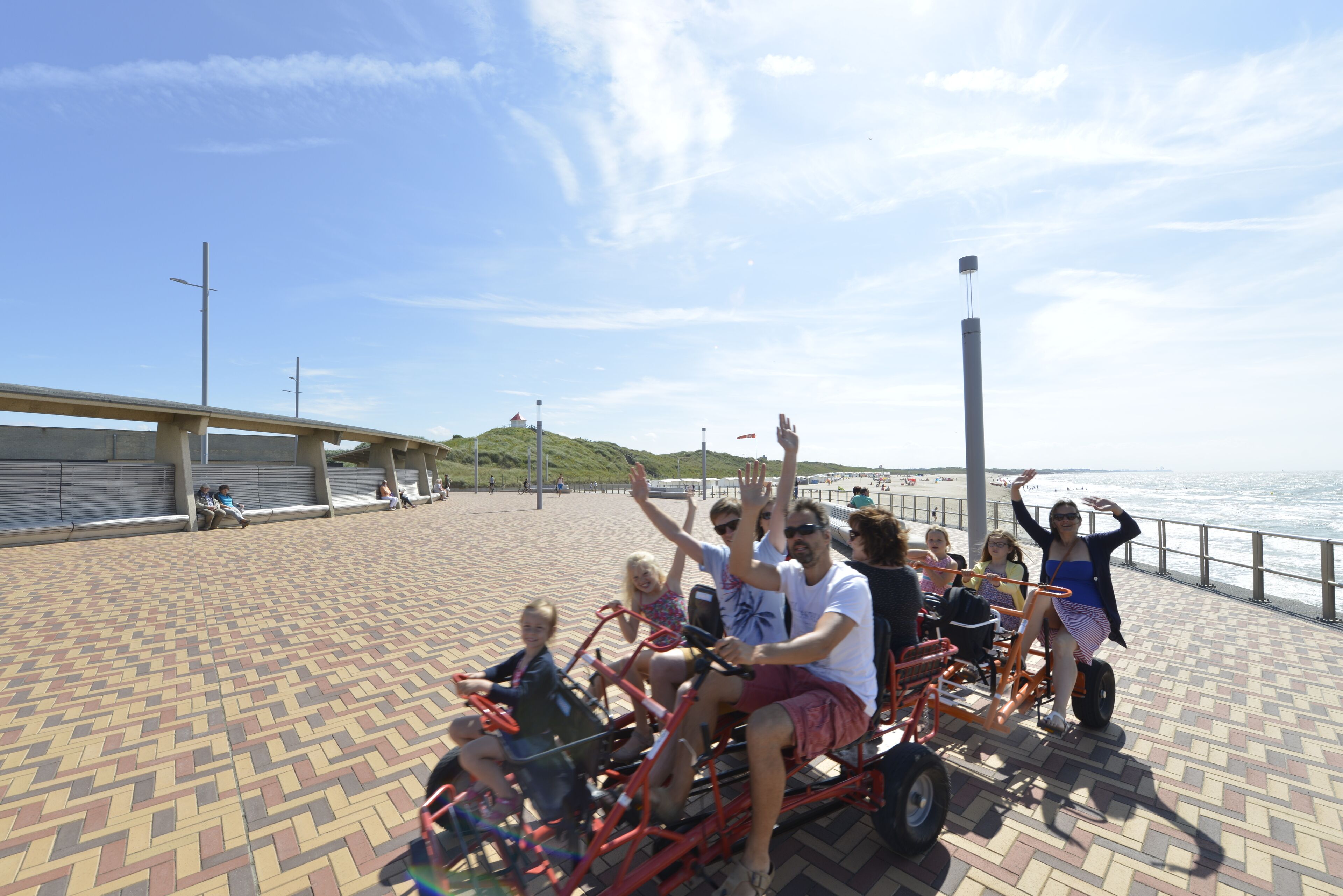 Een groep mensen op een strandpromenade met uitzicht op de oceaan.