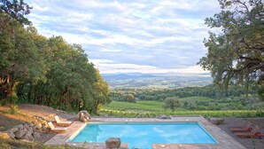 Una piscina con vistas a un valle y montañas.