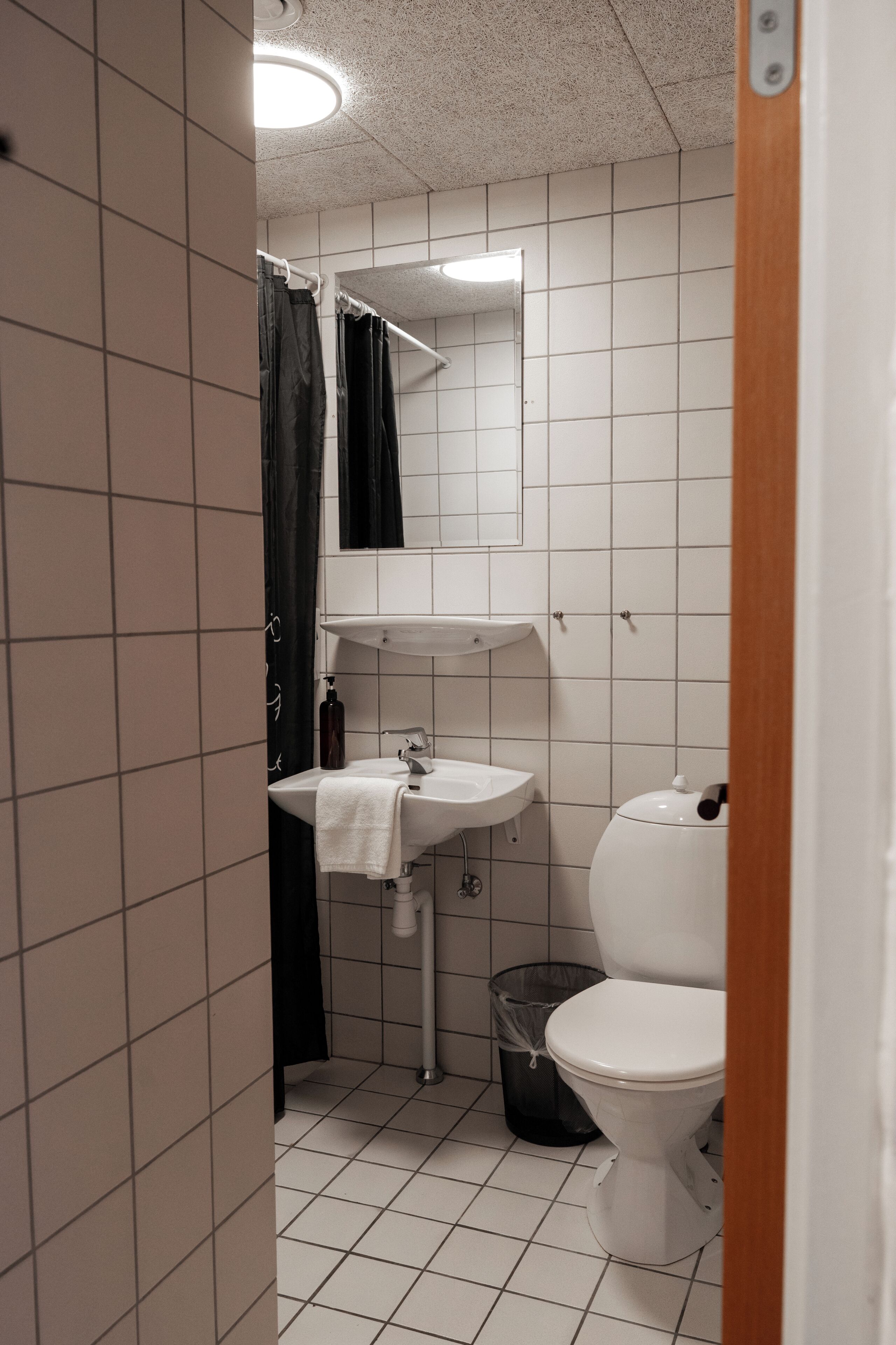 A small bathroom with a white sink, a toilet, and a mirror above the sink.