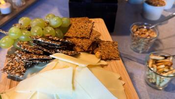 A table with a variety of food items including cheese, crackers, grapes, and nuts.