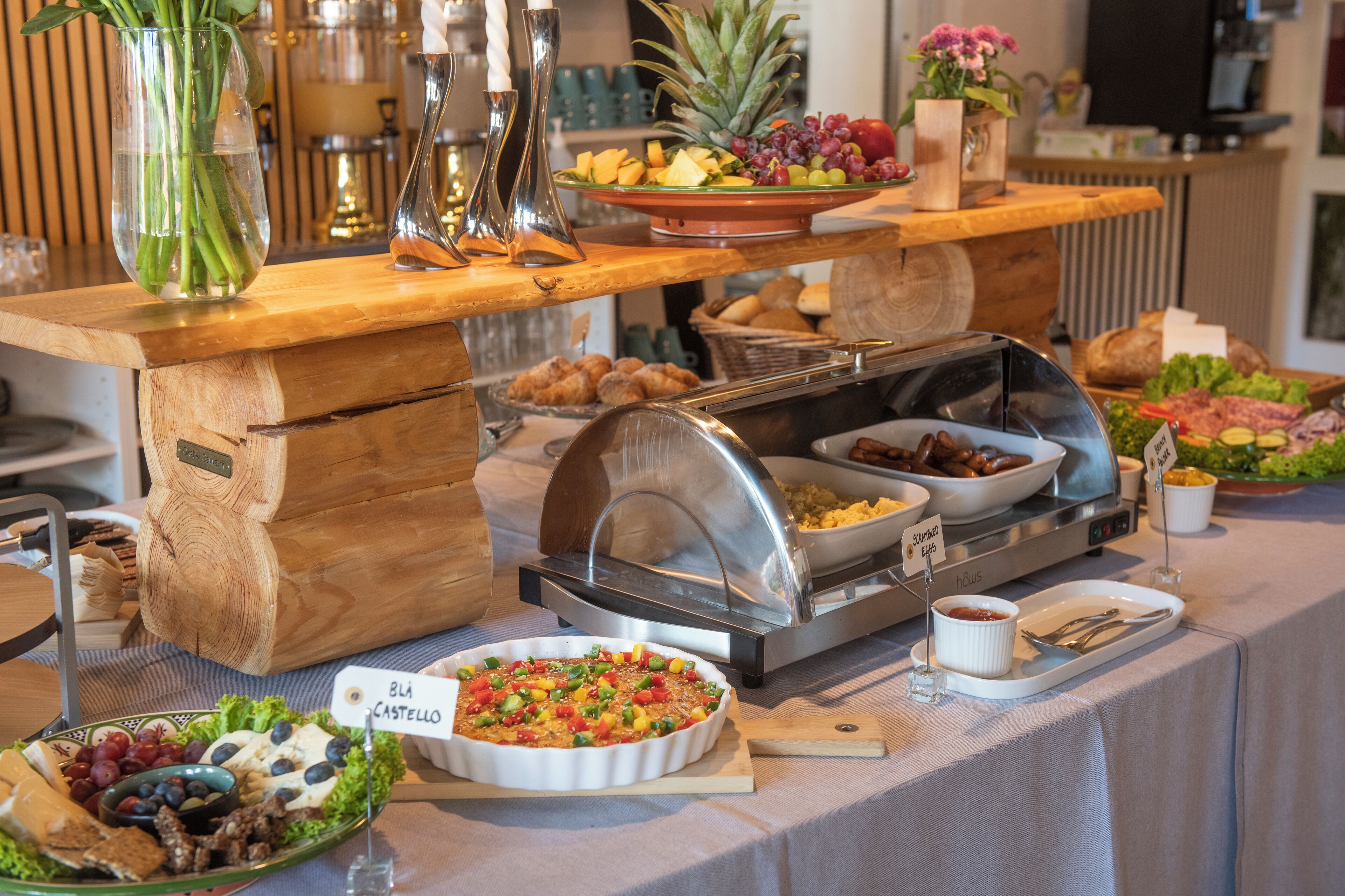 Buffet com diversos alimentos e uma placa indicando 'Blå Castello'.