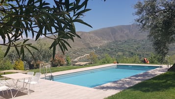 Una piscina al aire libre, tumbonas