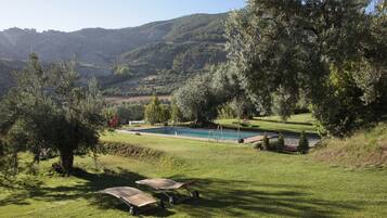 Relax by the serene pool surrounded by lush greenery and rolling hills.