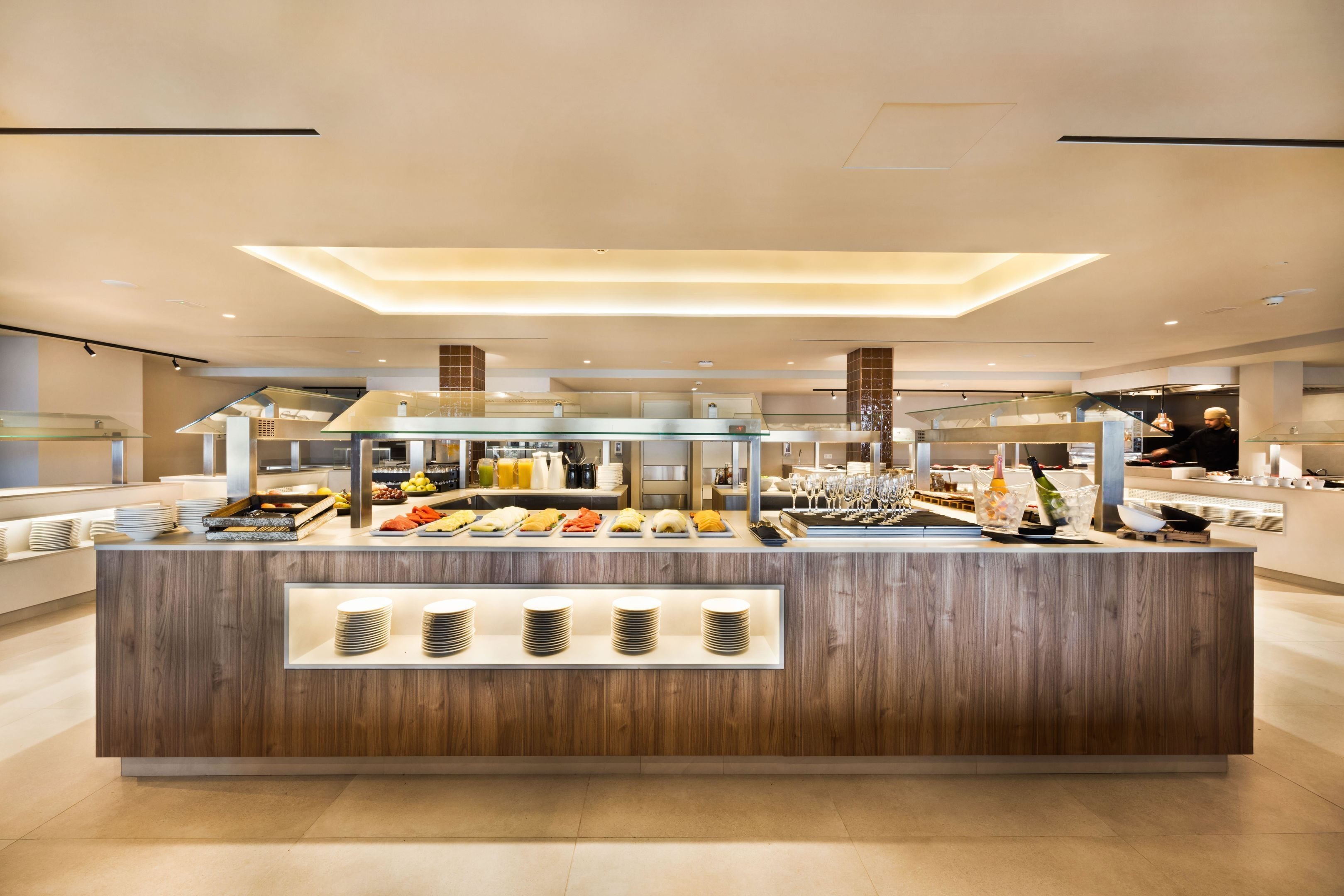 Un buffet moderne, avec un comptoir en bois, une variété de plats et une vitrine réfrigérée.