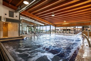 A large indoor swimming pool with a wooden ceiling and a view of the outside. - Hotel Inmood Aucanada - Adults Only (Alcúdia)
