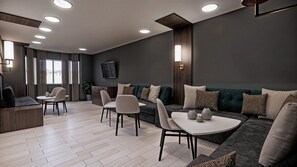 A modern living room with a sofa, chairs, a coffee table, and a TV mounted on the wall. - Residence Inn by Marriott Edmonton West (Edmonton)