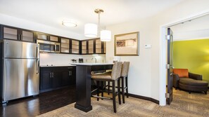 A modern kitchen with stainless steel appliances, a central island, and dark cabinetry.