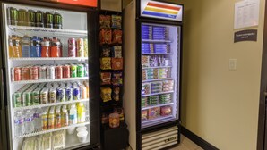 A vending machine stocked with snacks and beverages, including Coca-Cola and Monster energy drinks. - Staybridge Suites West Edmonton by IHG (Edmonton)