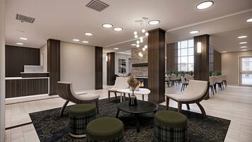 A modern lobby with seating, a reception desk, and a fireplace.