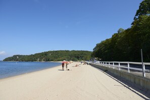 In Strandnähe, weißer Sandstrand, Liegestühle, Sonnenschirme