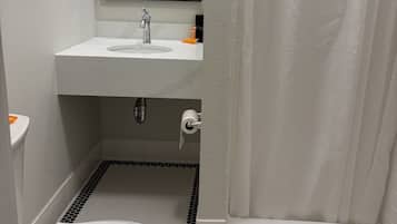 A bathroom with a toilet, sink, mirror, and shower curtain.