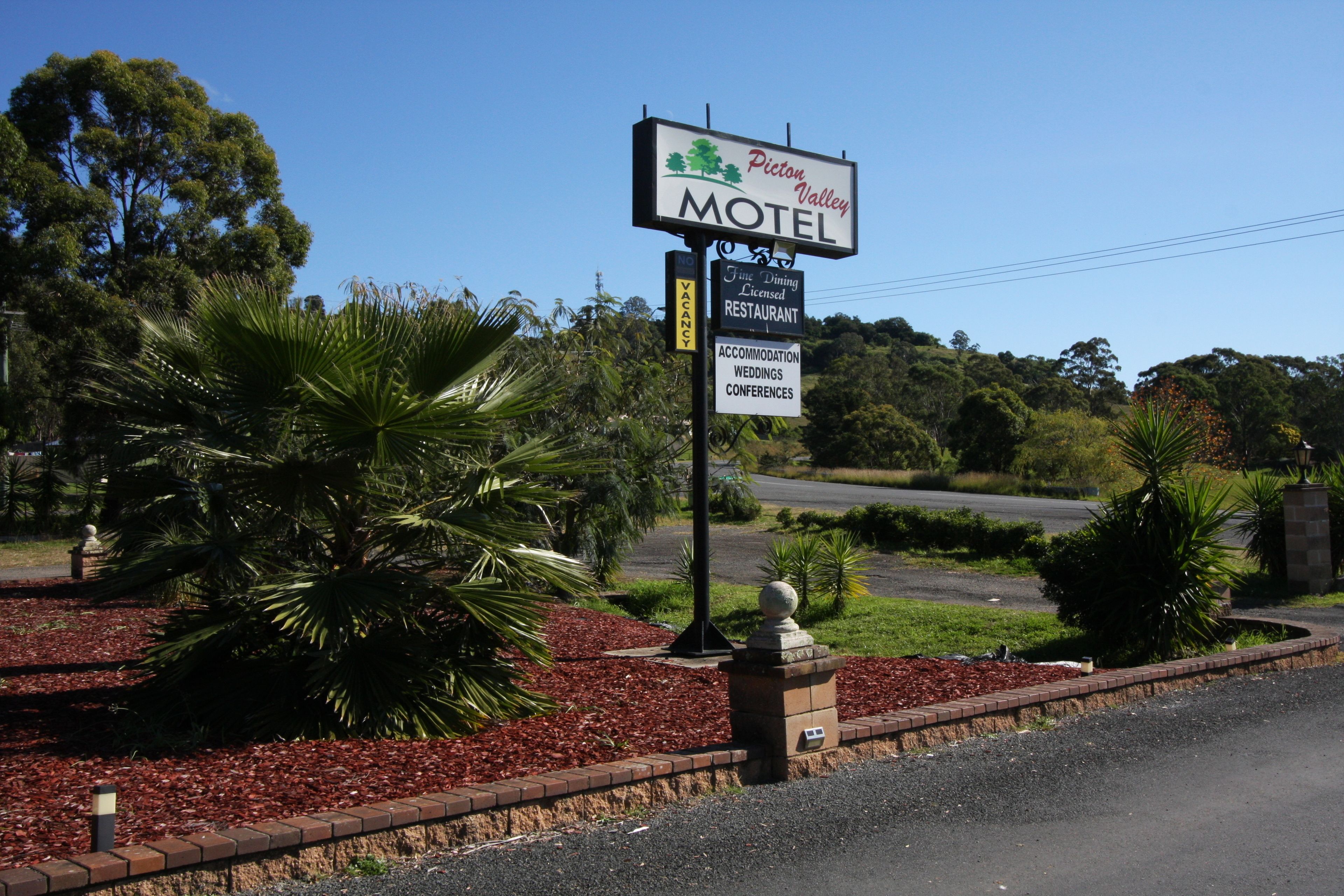 A motel sign with amenities including a fine dining restaurant, accommodation, weddings, and conferences.