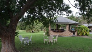 A gazebo with a brick base and metal roof, surrounded by a grassy lawn and trees. - Picton Valley Motel (Picton)