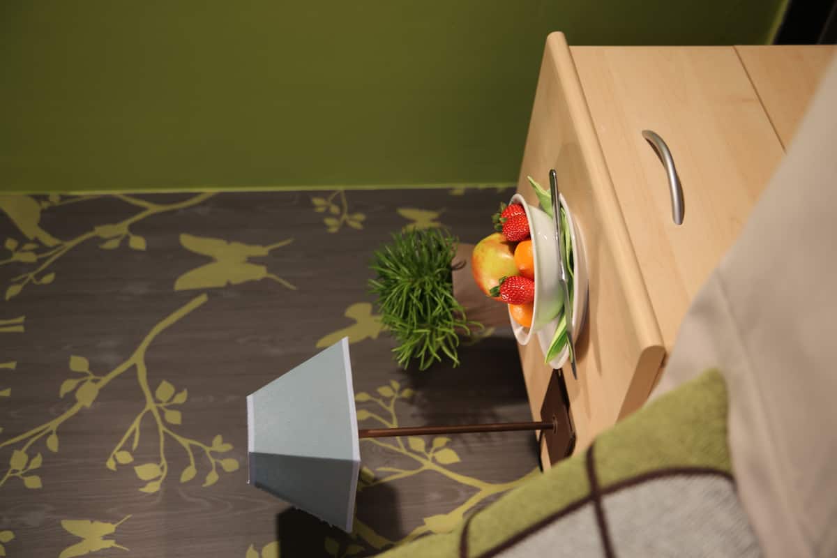 A wooden dresser with a plate of fruit and a small plant beside it.