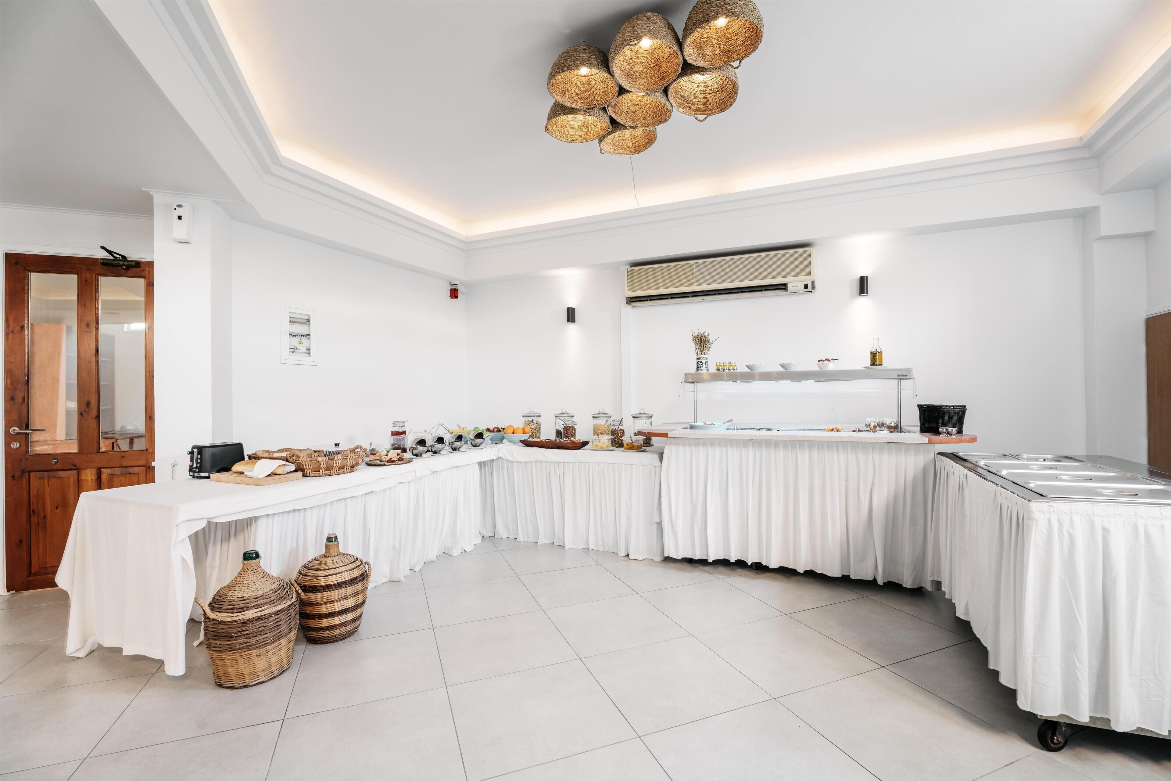 A buffet setup with a long table, wicker baskets, and a ceiling light fixture.