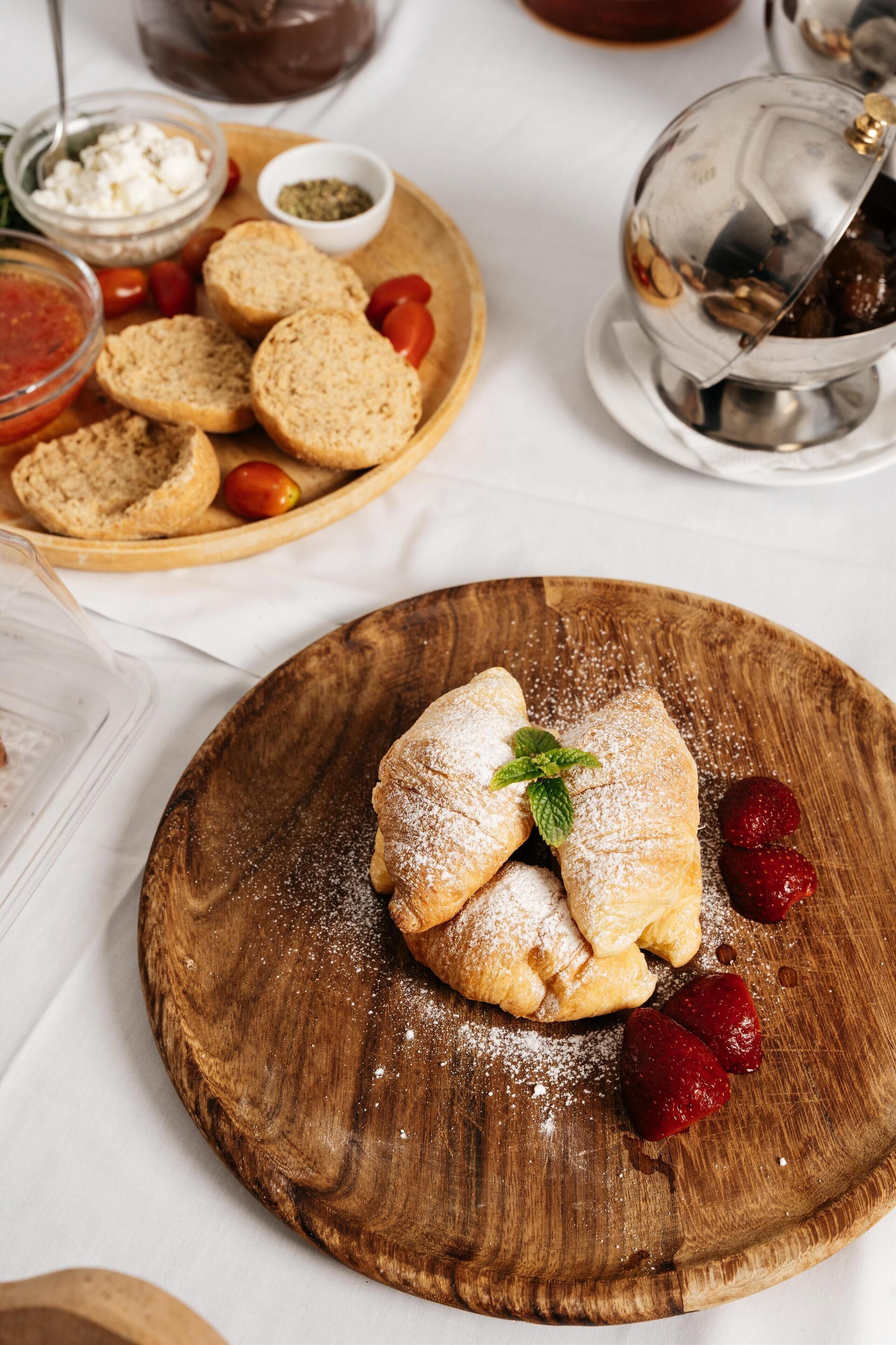 A wooden board with pastries and strawberries.