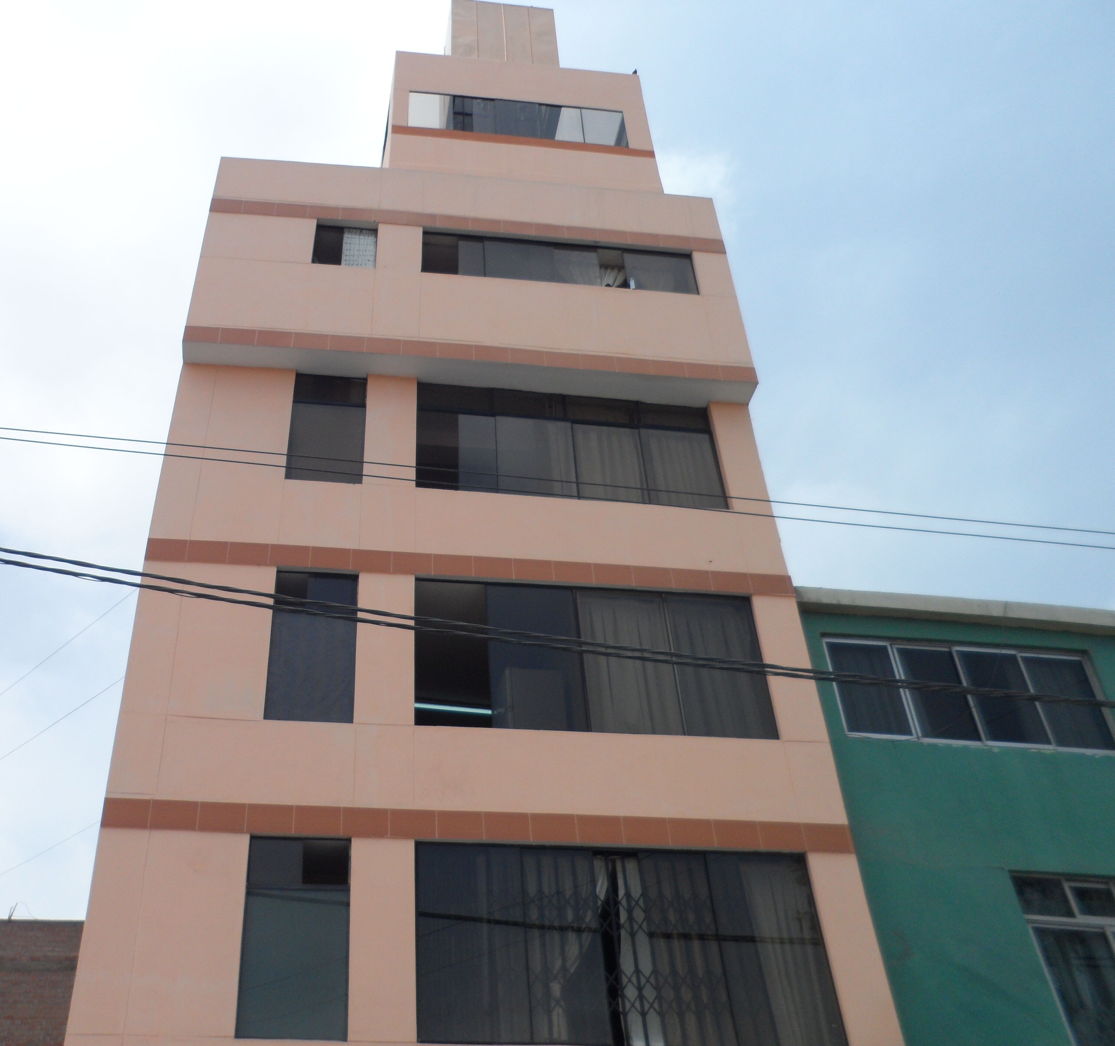 Un edificio de varios pisos con techo plano y ventanas amplias.