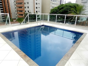 Alberca al aire libre y camastros