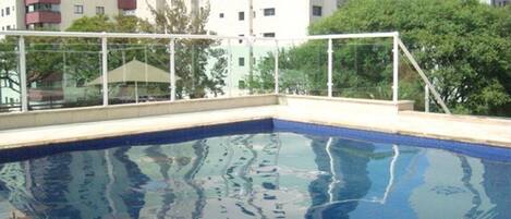 Una piscina al aire libre, tumbonas