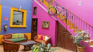 Un interior vibrante con una escalera, un sofá y una bicicleta.