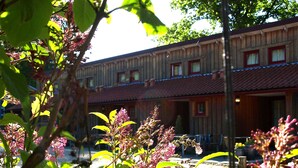 A wooden building with multiple windows and a red-tiled roof.