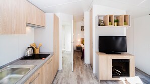 A modern kitchen with a built-in stove, a sink, and wooden cabinets.