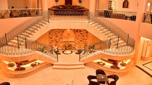 A hotel lobby with a central staircase, seating areas, and a 'DIVE INN' sign. - Dive Inn Resort (Sharm El Sheikh)