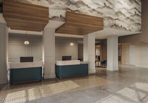A spacious lobby with a reception desk, seating area, and a patterned floor. - Pomeroy Inn & Suites Hotel Dawson Creek (Dawson Creek)