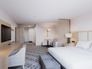 A hotel room with a bed, a desk, a television, and a seating area. - Pomeroy Inn & Suites Hotel Dawson Creek (Dawson Creek)