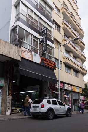 A multi-story building with a storefront featuring a sign for 'Centro Optico Mayorista de Colombia'.