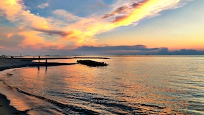 A beach with a calm sea, a pier, and a sunset. - Bay Haven Inn of Cape Charles (Cape Charles)