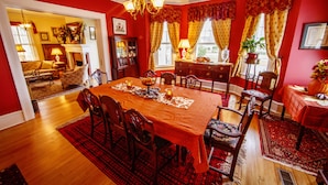 A dining room with a wooden table set for six, surrounded by chairs. - Bay Haven Inn of Cape Charles (Cape Charles)