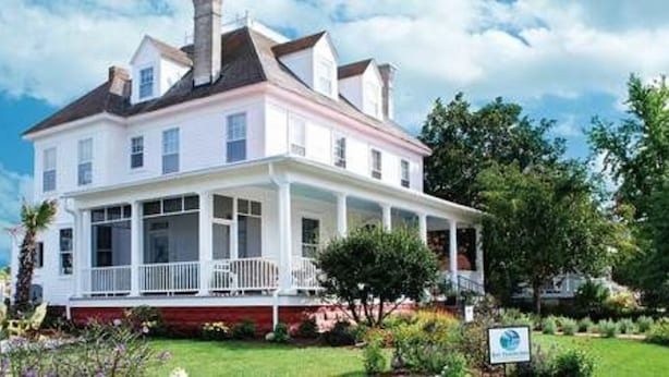 A two-story house with a porch, surrounded by a well-maintained garden. - Bay Haven Inn of Cape Charles (Cape Charles)