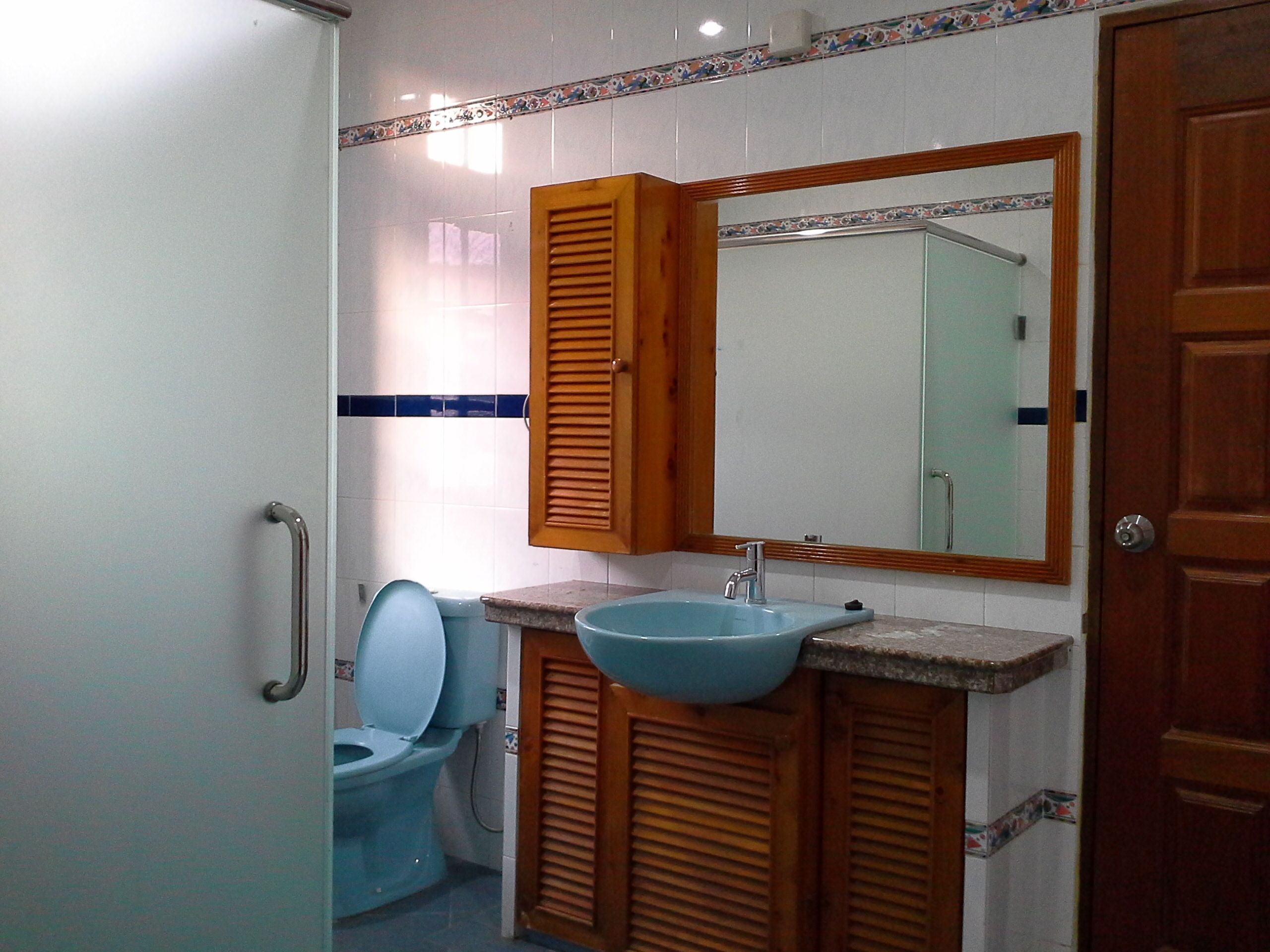 Un baño con inodoro, lavamanos y espejo.