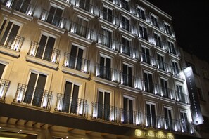 A multi-story hotel with balconies and illuminated windows at night. - Hotel Plaza Revolución (Mexico City)
